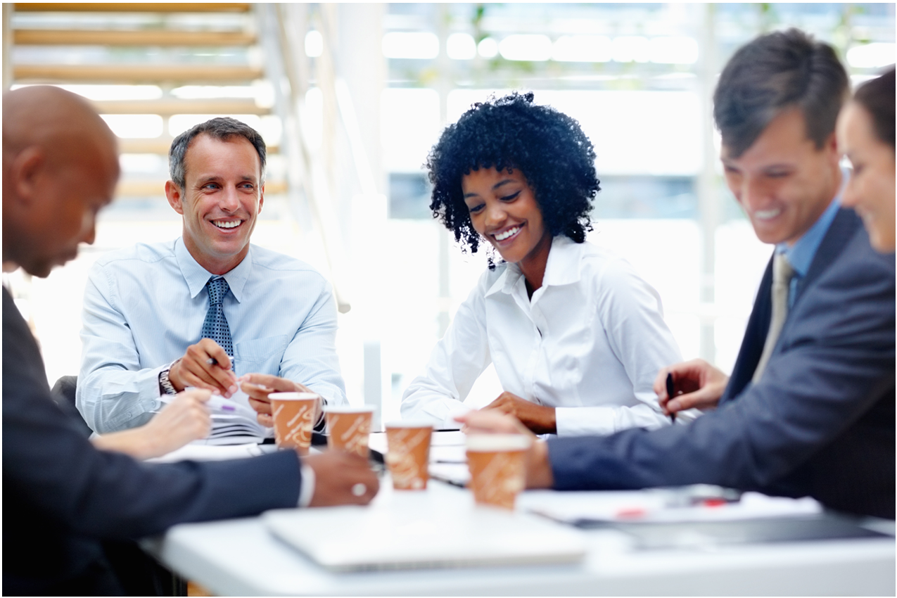 A diverse group of business professionals in a friendly collaborative meeting
